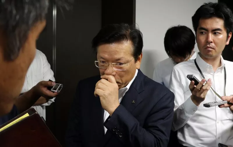 Japanese automaker Mitsubishi Motors president Tetsuro Aikawa is surrounded by reporters after he announced the company will close a plant in the United States at the company's headquarters in Tokyo on july 27, 2015. Mitsubishi will end vehicle production in the US at the end of November and will look for a buyer of the plant in Illinois.   AFP PHOTO / Yoshikazu TSUNO / AFP PHOTO / YOSHIKAZU TSUNO