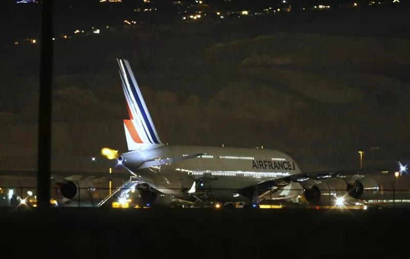 Air France Airbus 380, Flight 65,  sits on the runway at the Salt Lake City International Airport being inspected by the FBI on November 17, 2015 in Salt LAke City, Utah. Two Air France flights bound for Paris from the United States were diverted November 17, 2015 and landed safely after the airline received anonymous bomb threats, the carrier said.  Flight 65 from Los Angeles and Flight 55 from Washington were "subject to anonymous threats received after their respective takeoff," the airline said in a statement.   AFP PHOTO / GEORGE FREY