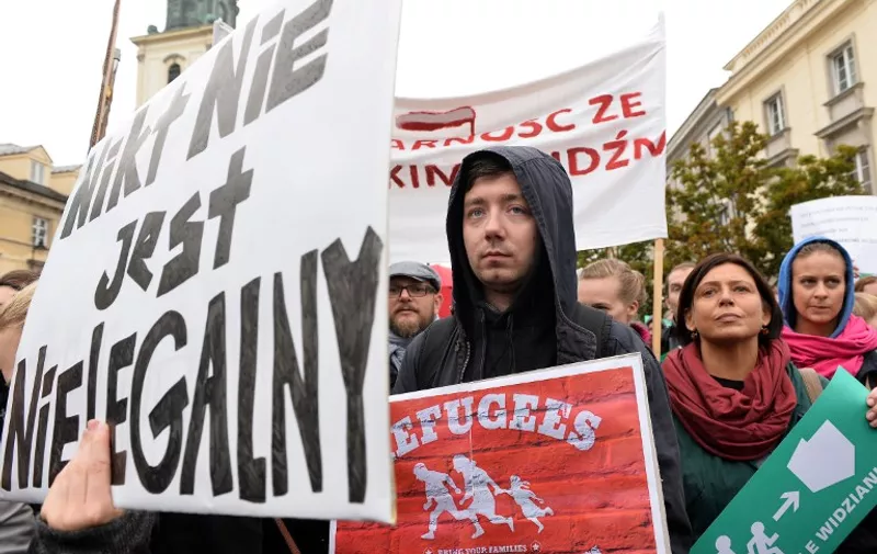 Participans of a pro-migrant demonstration hold placards written 'Refugees welcome' and 'No one is illegal' in Warsaw on September 12, 2015, as a counter-demonstration against a right-wing gathering against migrants at the same time. The counter-demonstration drew around 1,000 people welcoming migrants into Poland, an EU member of 38 million people which has seen virtually no refugees arriving during the current crisis.  AFP PHOTO / JANEK SKARZYNSKI