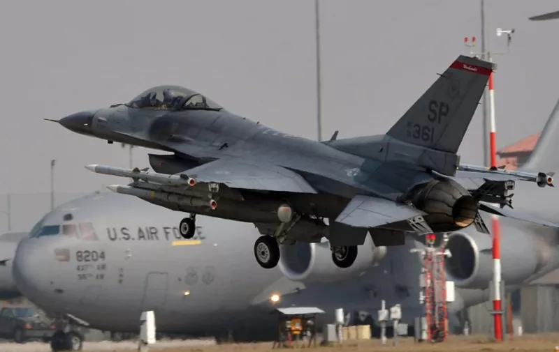 A US airforce F16 lands in front of a C17 at the Aviano air base on March 25, 2011. Western powers the same day in Brussels struggled on to define the shape and role of the international coalition on Libya as a bid to hand NATO command of military operations inched ahead but remained unresolved. 