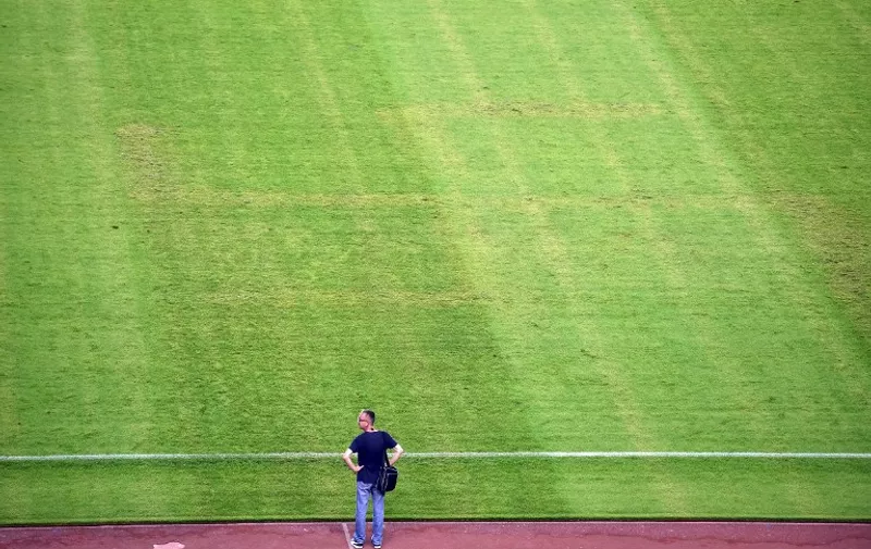 A man looks at the pitch appearing to show the pattern of a swastika following the the Euro 2016 qualifying football match between Croatia and Italy at the Poljud stadium in Split on June 12, 2015.   AFP PHOTO / ANDREJ ISAKOVIC