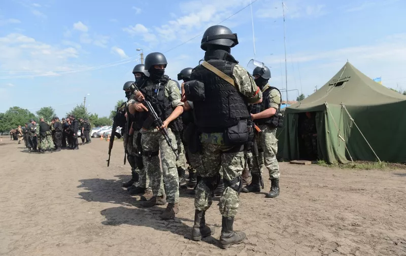 Ukrainian troops stand guard at the headquarters of the Ukrainian army's Anti-Terrorist Operation (ATO) near the eastern Ukrainian city of Izyum, near Donetsk, on June 20, 2014.  Poroshenko announced on June 20 that a week-long unilateral ceasefire would begin in the separatist east later in the day to give the pro-Russian rebels a chance to disarm. AFP PHOTO/ SERGEY BOBOK (Photo by SERGEY BOBOK / AFP)