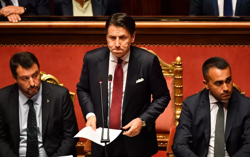 Italian Prime Minister Giuseppe Conte (C), flanked by Deputy Prime Minister and Interior Minister Matteo Salvini (L) and by Deputy Prime Minister and Minister of Economic Development, Labour and Social Policies, Luigi Di Maio (R), reacts as he delivers a speech at the Italian Senate, in Rome, on August 20, 2019, as the country faces a political crisis. - Italy's Premier Conte says to offer resignation during his speech at the Senate after calling Italy's far-right Interior Minister Matteo Salvini "irresponsible" to spark a political crisis by pulling the plug on the governing coalition. (Photo by Andreas SOLARO / AFP)