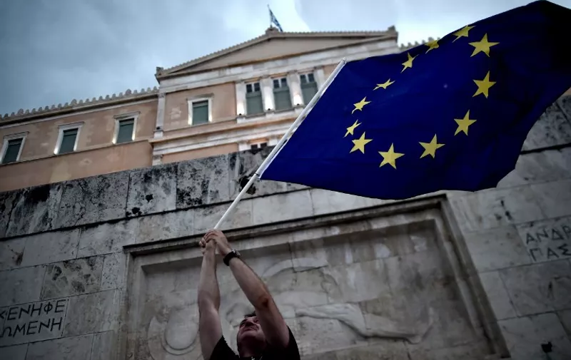A pro-European Union protester waves an EU flag during a demonstration in front of the parliament in Athens on June 30, 2015. 2015.   Thousands of people rallied in Athens in support of a bailout deal with international creditors which has been rejected by Prime Minister Alexis Tsipras, leaving Greece on the brink of default.  AFP PHOTO / ARIS MESSINIS