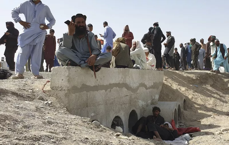 Stranded people wait for the reopening of the border crossing point which was closed by the authorities, in Chaman on August 7, 2021, after the Taliban took control of the Afghan border town in a rapid offensive across the country. (Photo by Asghar ACHAKZAI / AFP)