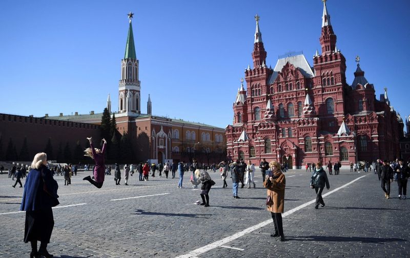 People walk along the Red Square during a warm and sunny day in Moscow on March 20, 2022. (Photo by AFP)