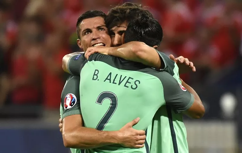 Portugal's forward Cristiano Ronaldo (L)  embraces Portugal's defender Bruno Alves and  Portugal's midfielder Adrien Silva (C) at the end of their match in the Euro 2016 semi-final football match between Portugal and Wales at the Parc Olympique Lyonnais stadium in Décines-Charpieu, near Lyon, on July 6, 2016.

Portugal beat Wales 2-0 to go into the finals. / AFP PHOTO / PHILIPPE DESMAZES