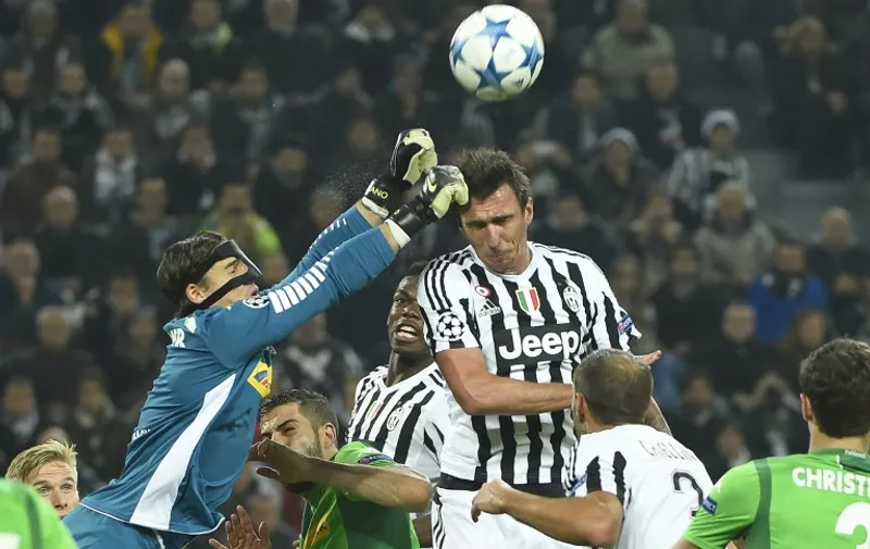 Moenchengladbach's Swiss goalkeeper Yann Sommer (L) deflects the ball as Juventus' forward from Croatia Mario Mandzukic (C) jumps for the ball during the UEFA Champions League football match Juventus vs Borussia Monchengladbach on October 21, 2015 at the Juventus stadium in Turin. AFP PHOTO / OLIVIER MORIN