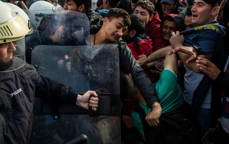 Migrants and refugees scuffle with riot police on the Greek Aegean island of Lesbos, on March 3, 2020, amid a migration surge from neighbouring Turkey after it opened its borders to thousands of refugees trying to reach Europe. Several aid groups on Greece's Lesbos said they were suspending work with refugees and evacuating staff on March 3 in the wake of violence and threats, as tensions soar on an island in the crosshairs of the migrant crisis. EU chiefs pledged millions of euros of financial assistance to Greece to help tackle the migration surge., Image: 502787389, License: Rights-managed, Restrictions: , Model Release: no, Credit line: ANGELOS TZORTZINIS / AFP / Profimedia