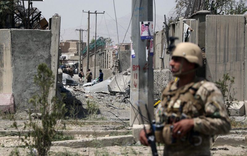 An Afghan security personnel stands guard at the site where a Taliban car bomb detonated at the entrance of a police station in Kabul on August 7, 2019. - Scores of people were wounded when a Taliban car bomb detonated in Kabul on August 7, sending a massive plume of smoke over the Afghan capital and shattering windows far from the blast site. (Photo by STR / AFP)