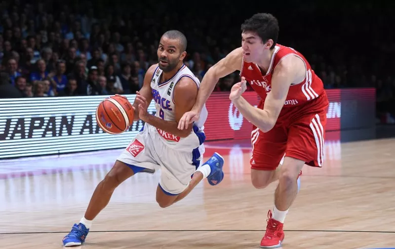 Turkey's small forward Cedi Osman (R) defends against France's point guard Tony Parker during the round of 16 basketball match between France and Turkey at the EuroBasket 2015 in Lille, northern France, on September 12, 2015.  AFP PHOTO / EMMANUEL DUNAND