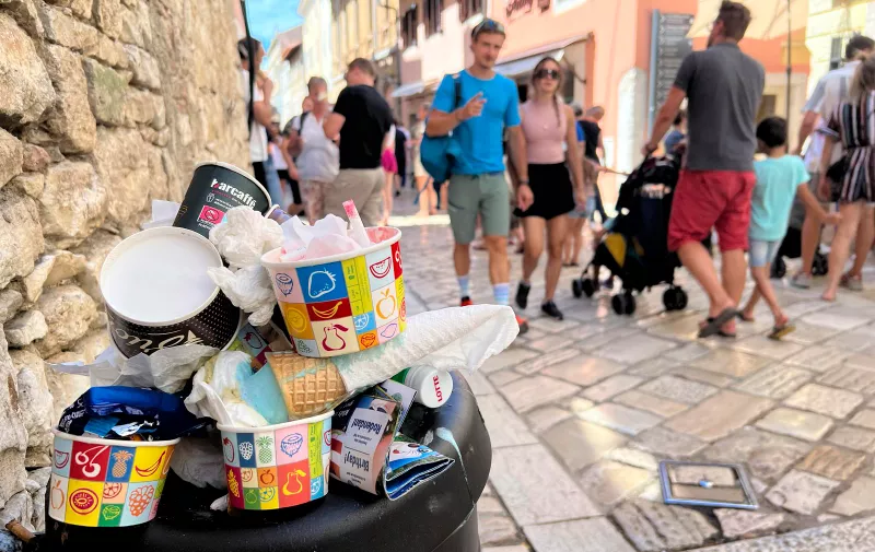 Full garbage can in a alley in the old town of Porec / Istria in Croatia. Passers-by, people walk past aller sundaes, ? Photo: Frank Hoermann / SVEN SIMON/DPA