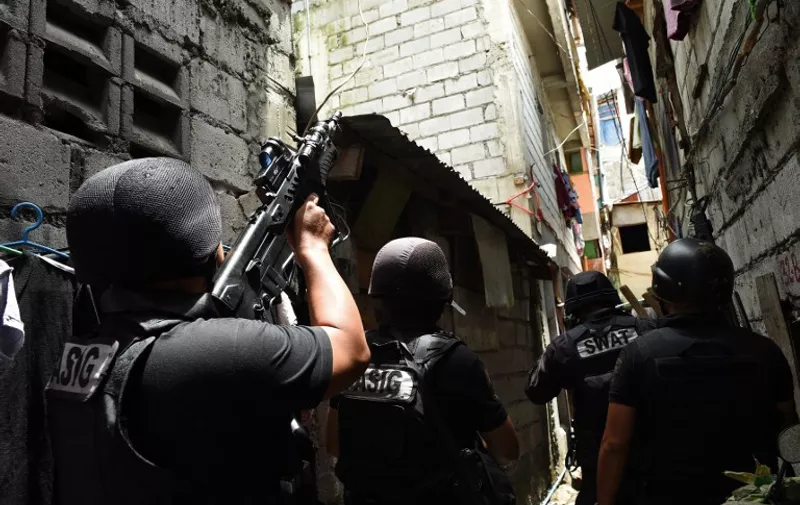 Philippine police SWAT personnel take position as they serve a search warrant to a resident in relation to drugs at an informal settler house in Pasig City, suburban Manila on September 5, 2016. 
The Philippines police chief warned on September 5 that his officers were prepared to kill anyone, even rich and influential politicians, as they wage President Rodrigo Duterte's deadly war on drugs. / AFP PHOTO / TED ALJIBE