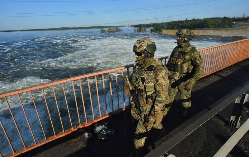 This photo taken on May 20, 2022 shows Russian servicemen patrolling at the Kakhovka Hydroelectric Power Plant, Kherson Oblast, amid the ongoing Russian military action in Ukraine. (Photo by Olga MALTSEVA / AFP)