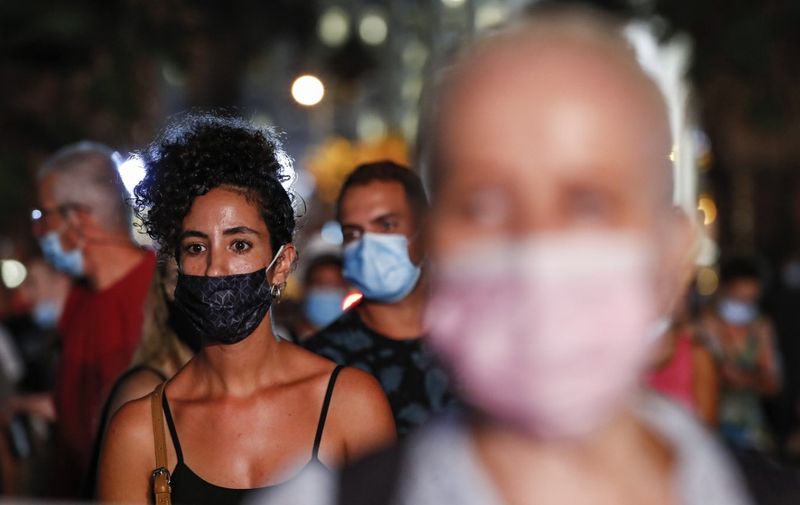 Anti-government demonstrators clad in masks due to the COVID-19 coronavirus pandemic gather during a protest in Charles Clore Park in the Mediterranean coastal city of Tel Aviv on July 18, 2020, protesting against the Israeli government and the PM for the broken (Photo by Jack GUEZ / AFP)