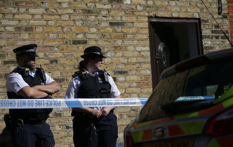 Police stand at the entrance to a property, where the charred remains of a body were found in the back garden, in Southfields, south-west London on September 22, 2017.  
A 40 year-old man and 34 year-old woman appeared in court on September 22, charged with murder after the discovery of a badly burned body in a garden. / AFP PHOTO / Daniel LEAL-OLIVAS