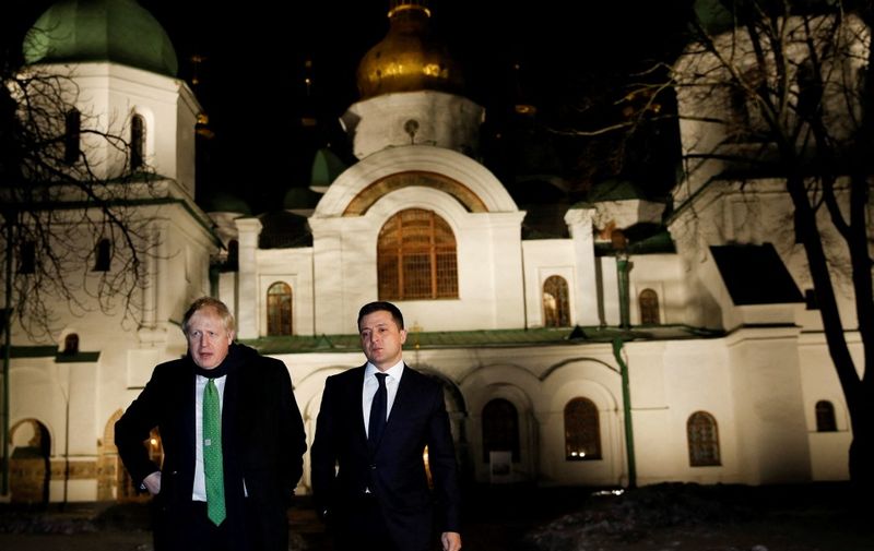 British Prime Minister Boris Johnson (L) and Ukrainian President Volodymyr Zelensky (R) interact in Kyiv on February 1, 2022. (Photo by PETER NICHOLLS / POOL / AFP)