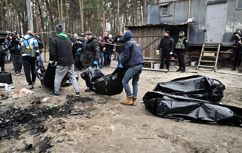 EDITORS NOTE: Graphic content / City workers carry body bags with six partially burnt bodies found in the town of Bucha on April 5, 2022, as Ukrainian officials say over 400 civilian bodies have been recovered from the wider Kyiv region, many of which were buried in mass graves. - Bucha had been occupied by Russian troops, but when they withdrew recently Ukrainian authorities and independent international journalists including AFP found bodies of people in civilian clothing, some with their hands tied behind their backs. (Photo by Genya SAVILOV / AFP)