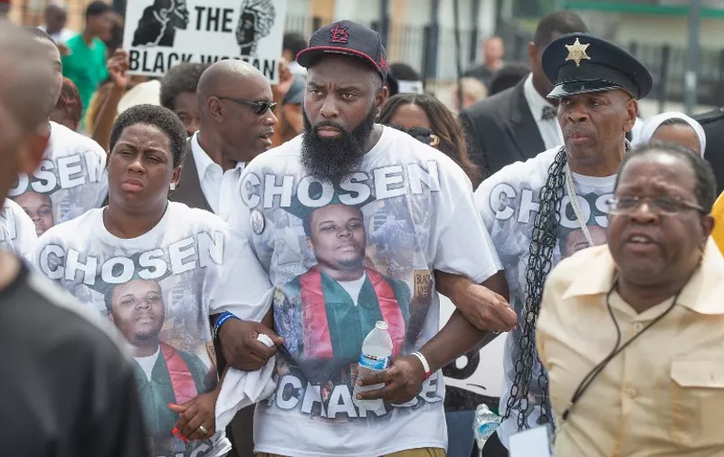FERGUSON, MO - AUGUST 09: Michael Brown Sr. (C) leads a march from the location where his son Michael Brown Jr. was shot and killed following a memorial service marking the anniversary his death on August 9, 2015 in Ferguson, Missouri. Brown Jr, was shot and killed by a Ferguson police officer on August 9, 2014. His death sparked months of sometimes violent protests in Ferguson and drew nationwide focus on police treatment of black offenders.   Scott Olson/Getty Images/AFP