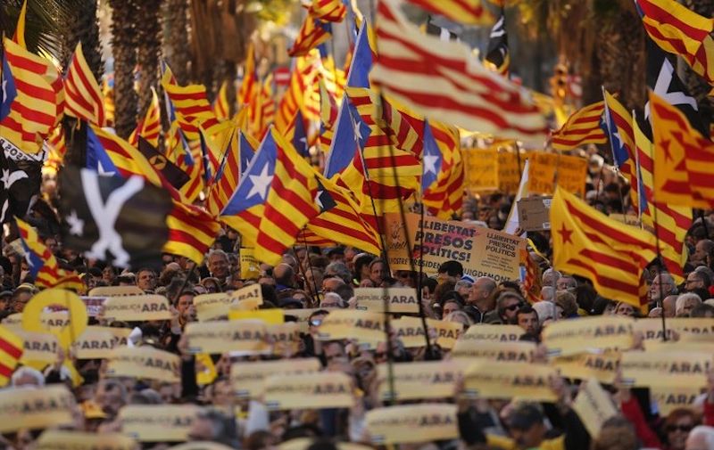 Demonstrators wave Catalan pro independence 'Estelada' flags as they protest to demand a Catalan republic, called by the pro-independence Catalan National Assembly (ANC) citizens' group in Barcelona on March 11, 2018.
Catalonia's separatist push has triggered Spain's worst crisis in decades.  / AFP PHOTO / Pau Barrena