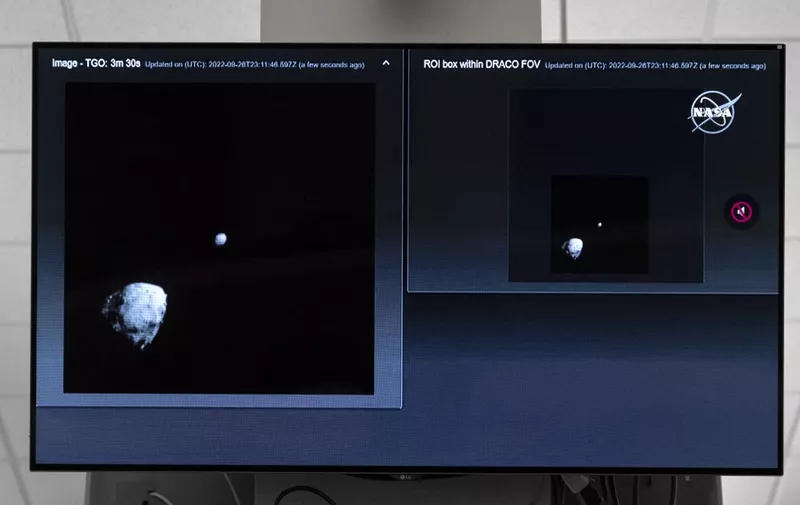 A television at NASA's Kennedy Space Center in Cape Canaveral, Florida, captures the final images from the Double Asteroid Redirection Test (DART) as it approaches asteroid Dimorphos (R), past asteroid Didymos (L), on September 26, 2022. - NASA's DART spaceship on September 26 struck the moonlet asteroid Dimorphos, in a historic test of humanity's ability to prevent a cosmic object devastating life on Earth. (Photo by Jim WATSON / AFP)