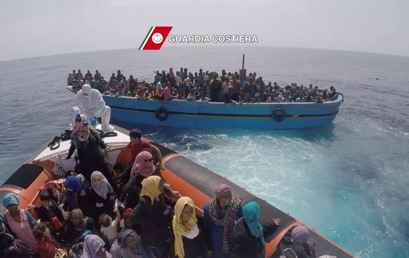 In this video grab released by the Italian Coast Guards (Guardia Costiera) on June 7, 2015 migrants sit on a boat during a rescue operation off the coast of Sicily as part of the Frontex-coordinated Operation Triton. Nearly 3,500 migrants were rescued on June 6, 2015 from 15 boats off the coast of Libya, Italy's coastguard said. The boats -- nine wooden boats thought to be converted fishing vessels and six large rubber dinghies -- were all found drifting around 45 miles off the Libyan coast after issuing distress calls via satellite phone on Saturday morning, the coastguard said.  AFP PHOTO / HO
= RESTRICTED TO EDITORIAL USE - MANDATORY CREDIT "AFP PHOTO / GUARDIA COSTIERA" - NO MARKETING NO ADVERTISING CAMPAIGNS - DISTRIBUTED AS A SERVICE TO CLIENTS =