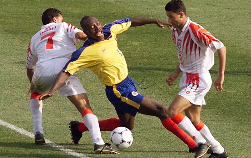 Colombian Freddy Rincon (C) is challenged by Tunisian players Tarek Thabet (L) and Zoubele Baya, 22 June at the Stade de la Mosson in Montpellier, south of France, during the 1998 Soccer World Cup Group G first round match between Colombia and Tunisia. Colombia won 1-0.
(ELECTRONIC IMAGE) AFP PHOTO 