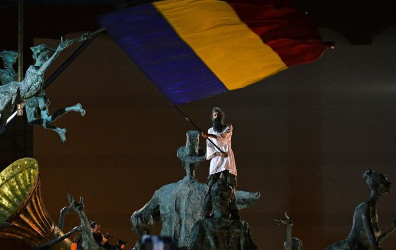 A protester wave Romanian flag as he climbed on a monument during the fifteen day of demonstrations in Bucharest against the Rosia Montana Gold Corporation (RMGC), a Canadian gold mine project using cyanide, on September 15, 2013. Around 20,000 people from around Romania took to the streets Sunday to protest against plans by a Canadian company to open Europe's largest goldmine in a Transylvanian village. Canadian company Gabriel Resources hopes to extract 300 tons of gold using thousands of tons of cyanide in Rosia Montana, a picturesque village in the Carpathian mountains. The government recently adopted a bill clearing the way for the open cast mine. AFP PHOTO / DANIEL MIHAILESCU / AFP PHOTO / DANIEL MIHAILESCU