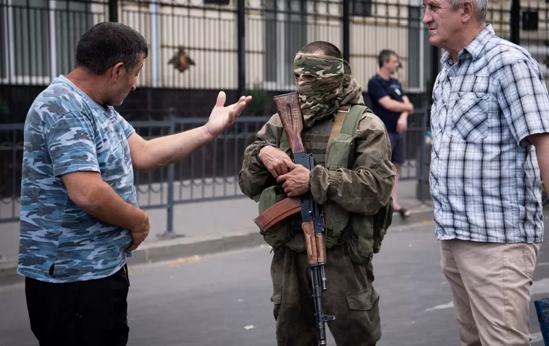 A local resident speaks with a member of Wagner group in Rostov-on-Don, on June 24, 2023. President Vladimir Putin on June 24, 2023 said an armed mutiny by Wagner mercenaries was a "stab in the back" and that the group's chief Yevgeny Prigozhin had betrayed Russia, as he vowed to punish the dissidents. Prigozhin said his fighters control key military sites in the southern city of Rostov-on-Don. (Photo by Roman ROMOKHOV / AFP) / The erroneous mention[s] appearing in the byline of this photo has been modified in AFP systems in the following manner: [Roman Romokhov] instead of [Denis Romanov]. Please immediately remove the erroneous mention[s] from all your online services and delete it (them) from your servers. If you have been authorized by AFP to distribute it (them) to third parties, please ensure that the same actions are carried out by them. Failure to promptly comply with these instructions will entail liability on your part for any continued or post notification usage. Therefore we thank you very much for all your attention and prompt action. We are sorry for the inconvenience this notification may cause and remain at your disposal for any further information you may require.