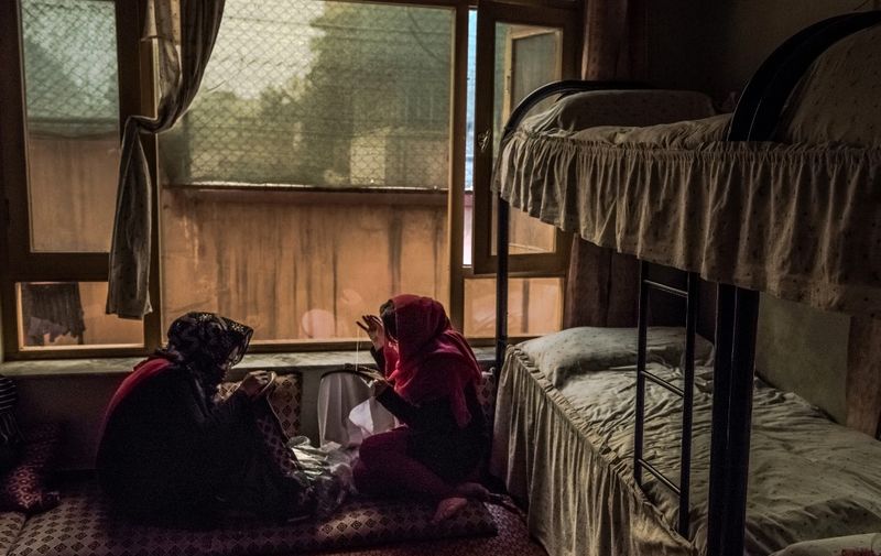 In this photograph taken on March 20, 2017, Afghan women sew in their bedroom at a women's shelter in Kabul. - A non-descript building, tucked away in a residential neighbourhood in the Afghan capital, is one of the few hidden sanctuaries where battered women can seek support. Managed by the charity Women for Afghan Women (WAW), the shelter has given a new lease of life to women in a country where rape, abuse and forced marriages are commonplace. (Photo by Rebecca CONWAY / AFP) / TO GO WITH 'Afghanistan-social-abuse-women', FEATURE BY Anne CHAON