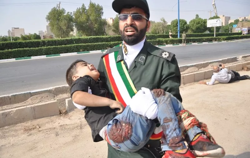 This picture taken on September 22, 2018 in the southwestern Iranian city of Ahvaz shows a member of Iran's Revolutionary Guards Corps (IRGC) carrying an injured child at the scene of an attack on a military parade that was marking the anniversary of the outbreak of its devastating 1980-1988 war with Saddam Hussein's Iraq.
Dozens of people were killed with dozens others wounded in an attack in the southwestern Khuzestan province on September 22 targeting on an army parade commemorating the anniversary of the 1980-1988 Iran Iraq war, state media reported. / AFP PHOTO / ISNA / Behrad GHASEMI / ìThe erroneous mention[s] appearing in the metadata of this photo by Shayan HAJI NAJAF has been modified in AFP systems in the following manner: [Behrad Ghasemi] instead of [Shayan Haji Najfi ]. Please immediately remove the erroneous mention[s] from all your online services and delete it (them) from your servers. If you have been authorized by AFP to distribute it (them) to third parties, please ensure that the same actions are carried out by them. Failure to promptly comply with these instructions will entail liability on your part for any continued or post notification usage. Therefore we thank you very much for all your attention and prompt action. We are sorry for the inconvenience this notification may cause and remain at your disposal for any further information you may require.î