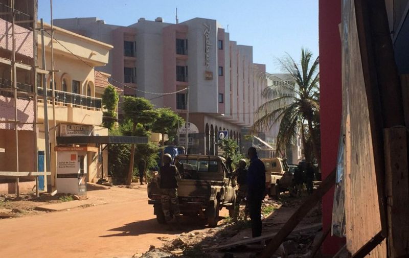 Malian troops take position outside the Radisson Blu hotel in Bamako on November 20, 2015. Gunmen went on a shooting rampage at the luxury Radisson Blu hotel in Mali's capital Bamako, seizing 170 guests and staff in an ongoing hostage-taking, the hotel chain said. AFP PHOTO / SEBASTIEN RIEUSSEC / AFP / Sebastien RIEUSSEC