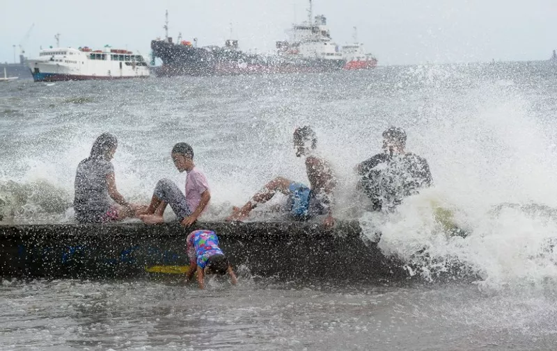 TOPSHOTS
Residents along Manila Bay play in the waves created by nearby Typhoon Noul on May 10, 2015 as it approaches the northern Philippines. More than 2,000 people were fleeing their homes as Typhoon Noul approached the northern Philippines on May 10, triggering warnings of possible flash floods, landslides and tsunami-like storm surges.   AFP PHOTO / Jay DIRECTO