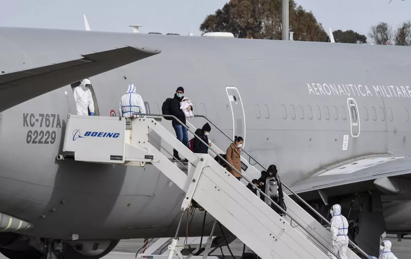 This photo taken and handout on February 3, 2020 by the Italian Defence Ministry Press Office shows Italian citizens repatriated from the coronavirus hot-zone of Wuhan exit an Italian Boeing KC-767 military aerial refueling and strategic transport aircraft, after landing at the Mario De Bernardi military airport in Pratica di Mare, south of Rome, to be placed in quarantine at the nearby Cecchignola center., Image: 496216604, License: Rights-managed, Restrictions: RESTRICTED TO EDITORIAL USE - MANDATORY CREDIT "AFP PHOTO / ITALIAN DEFENCE MINISTRY PRESS OFFICE " - NO MARKETING NO ADVERTISING CAMPAIGNS - DISTRIBUTED AS A SERVICE TO CLIENTS ---, Model Release: no, Credit line: Handout / AFP / Profimedia