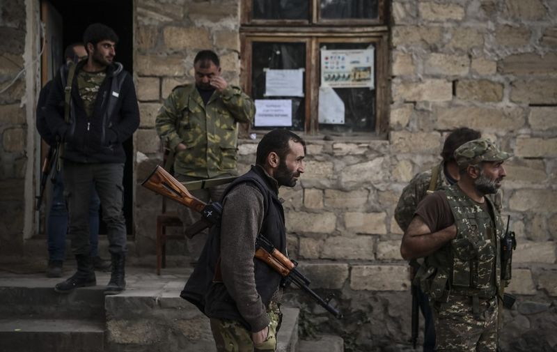 Volunteer fighters stand in a village south-east of Stepanakert on October 23, 2020, during the ongoing fighting between Armenian and Azerbaijani forces over the breakaway region of Nagorno-Karabakh. - The Russian president said on October 22 that the death toll was nearing 5,000 since full-scale fighting reputed last month, in the worst flare-up in the disputed Nagorno-Karabakh region in more than two decades. (Photo by ARIS MESSINIS / AFP)
