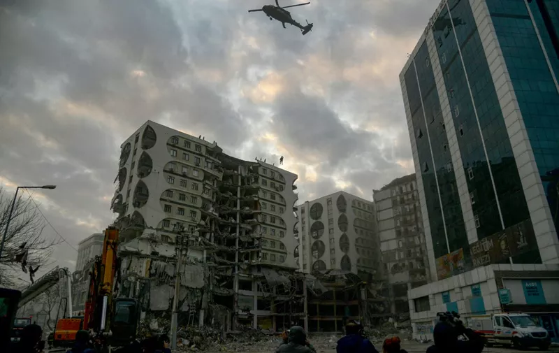 A member of the special forces attempts a helicopter landing on a damaged building thought to contain several animals in Diyarbakir, south-eastern Turkey, on February 22, 2023. Animal lovers in a Turkish city ravaged by a deadly earthquake protested on February 22, 2023, after officials sought to demolish a damaged building thought to contain several animals, AFP correspondents saw. (Photo by ILYAS AKENGIN / AFP)