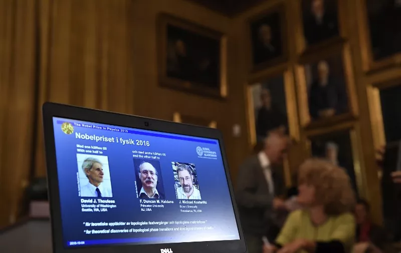 Winners of the Nobel Prize in Physics (L-R) David J Thouless, F Duncan M Haldane and J Michael Kosterlitz are displayed on a screen during a press conference to announce the winner of the 2016 Nobel Prize in Physics at the Royal Swedish Academy of Sciences in Stockholm on October 4, 2016. 
British-born scientists David J. Thouless, F. Duncan Haldane and J. Michael Kosterlitz won the Nobel Physics Prize for revealing the secrets of exotic matter, the Nobel jury said. / AFP PHOTO / JONATHAN NACKSTRAND