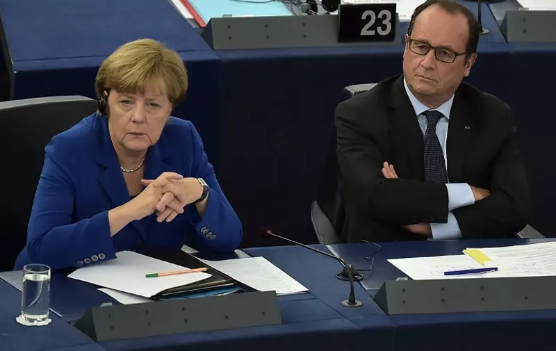 French President Francois Hollande (R) sits next to German Chancellor Angela Merkel (L) during their joint address at the European Parliament on October 7, 2015 in Strasbourg, eastern France. Angela Merkel and Francois Hollande are set to give a joint address, the first such event by leaders of the two countries since 1989. Merkel and Hollande, the leaders of the European Union's two biggest economies, have played a driving role in a series of challenges that have gripped the 28-nation bloc, ranging from the migrant crisis to the Greek debt saga and the conflict in Ukraine. Failure to act in Syria risks stoking a "total war" in the Middle East, Francois Hollande said in a landmark speech to the European Parliament alongside Angela Merkel.  AFP PHOTO / PATRICK HERTZOG
