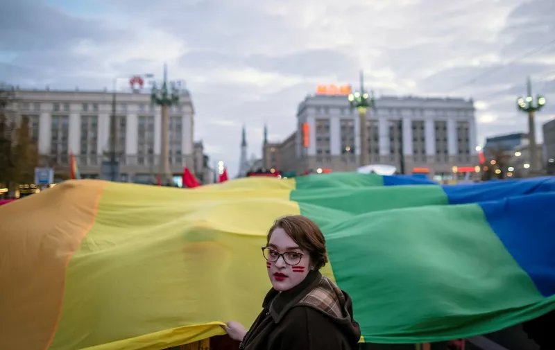A participant holds a giant rainbow flag during a counter-manifestation organised by left wing, anti-fascist, feminist and LGBT activists in opposition to the annual far-right Independence March marking Poland's National Independence Day on November 11, 2019 in Warsaw. (Photo by Wojtek RADWANSKI / AFP)