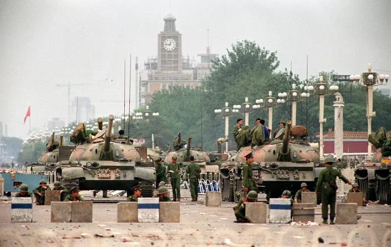 (FILES) This file photo taken on June 6, 1989 shows People's Liberation Army (PLA) tanks and soldiers guarding the strategic Chang'an Avenue leading to Tiananmen Square in Beijing two days after their crackdown on pro-democracy students. - While China might be exploiting fears of a bloody "Tiananmen" crackdown on Hong Kong's protest movement, analysts on August 12, 2019 say the potentially catastrophic economic and political consequences will deter Beijing from any overt boots-on-the ground intervention. (Photo by Manny CENETA / AFP) / TO GO WITH HongKong-unrest-China-politics-police,FOCUS by Patrick Baert