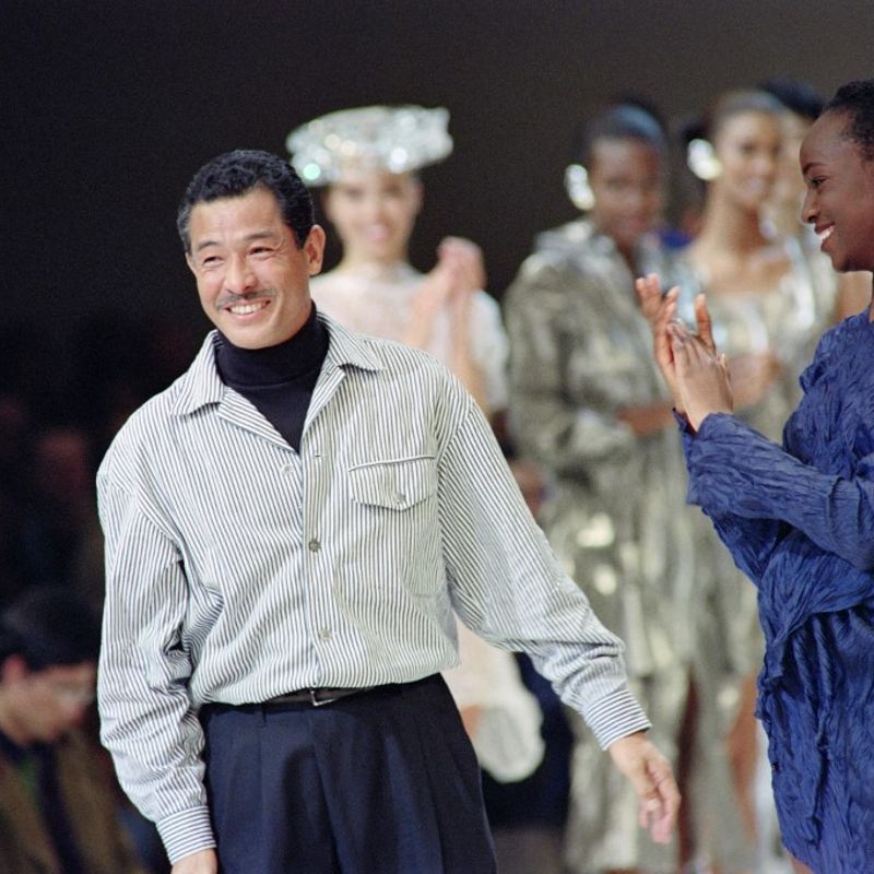 (FILES) This file photo taken on October 19, 1991 shows Japanese fashion designer Issey Miyake acknowledging the applause from models and attendees after presenting his 1992 Spring-Summer collection in Paris. - Japanese fashion designer Issey Miyake, whose global career spanned more than half a century, has died aged 84, an employee at his office in Tokyo told AFP on August 9, 2022. (Photo by Pierre GUILLAUD / AFP)