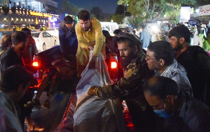 EDITORS NOTE: Graphic content / Volunteers and medical staff unload bodies from a pickup truck outside a hospital after two powerful explosions, which killed at least six people, outside the airport in Kabul on August 26, 2021. (Photo by Wakil KOHSAR / AFP)