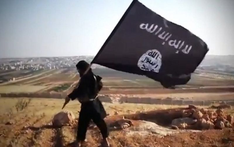 An image grab taken from a video uploaded on YouTube on August 23, 2013 allegedly shows a member of Ussud Al-Anbar (Anbar Lions), a Jihadist group affiliated to the Islamic State of Iraq and the Levant (ISIL), Al-Qaeda's front group in Iraq,  holding up the trademark black and white Islamist flag at an undisclosed location in Iraq's Anbar province. Attacks in Iraq killed 14 people including six soldiers on August 25, Iraqi officials said, amid a surge in violence authorities have so far failed to stem despite wide-ranging operations targeting militants. Arabic writing on the flag reads: "There is not God but God and Mohammed is the prophet of God."  AFP PHOTO / YOUTUBE  == RESTRICTED TO EDITORIAL USE - MANDATORY CREDIT "AFP PHOTO / YOUTUBE " - NO MARKETING NO ADVERTISING CAMPAIGNS - DISTRIBUTED AS A SERVICE TO CLIENTS FROM FROM ALTERNATIVE SOURCES, THEREFORE AFP IS NOT RESPONSIBLE FOR ANY DIGITAL ALTERATIONS TO THE PICTURE'S EDITORIAL CONTENT, DATE AND LOCATION WHICH CANNOT BE INDEPENDENTLY VERIFIED ====