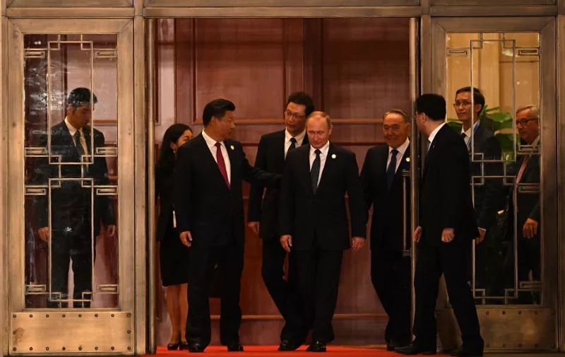 China's President Xi Jinping (centre L), Russia's President Vladimir Putin (C), Kazakhstan's President Nursultan Nazarbayev (centre R), and President of the European Commission Jean-Claude Juncker (R, behind window) walk with other G20 leaders and their spouses for a group picture prior to a dinner banquet at the G20 Summit in Hangzhou on September 4, 2016.
G20 leaders confront a sluggish global economy and the winds of populism as they open annual talks, but the long war in Syria and the South China Sea territorial dispute hang over the summit. / AFP PHOTO / Johannes EISELE