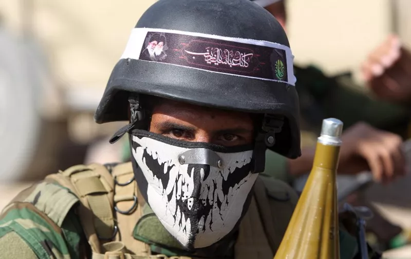 An Iraqi Shiite fighter from the Popular Mobilisation units, fighting alongside Iraqi forces, poses for a photo as they advance towards the centre of Baiji, some 200 kilometres north of Baghdad, during a military operation against Islamic State (IS) group jihadists on October 18, 2015. Iraqi forces advanced on three fronts against the Islamic State group, flushing out pockets of resistance in and around Baiji and closing in on Ramadi and Hawijah, officers said. AFP PHOTO / AHMAD AL-RUBAYE / AFP / AHMAD AL-RUBAYE