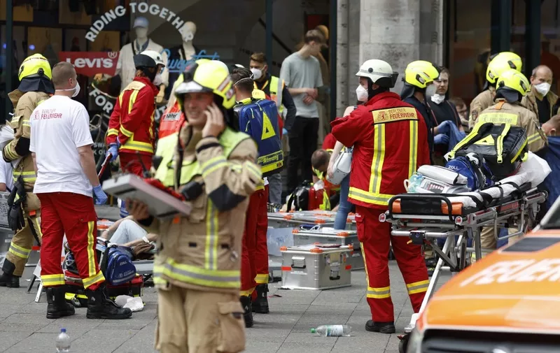 Rescue workers help injured people at the site where one person was killed and eight injured when a car drove into a group of people in central Berlin, on June 8, 2022. - A police spokeswoman said the driver was detained at the scene after the car ploughed into a shop front in a busy shopping street in Charlottenburg district. It was not clear whether the crash was intentional. (Photo by Odd ANDERSEN / AFP)