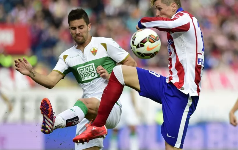 Atletico Madrid&#8217;s midfielder Gabi (L) vies with Elche&#8217;s midfielder Adrian Gonzalez during the Spanish league football match Club Atletico Madrid vs Elche FC at the Vicente Calderon stadium in Madrid on April 25, 2015. AFP PHOTO /