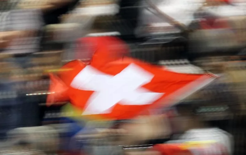 Swiss fans wave a national flag during the final race at the Losail International Circuit in Doha on March 20, 2011 ahead of the Grand Prix of Qatar. AFP PHOTO/KARIM JAAFAR / AFP / KARIM JAAFAR