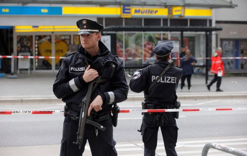 Police cordon off the area around a supermarket in the northern German city of Hamburg, where a man killed one person and wounded several others in a knife attack, on July 28, 2017. 
"There is no valid information yet on the motive or the number of people injured" by the man, who "entered a supermarket and suddenly began attacking customers", said police, adding that one victim died from his severe wounds. / AFP PHOTO / dpa / Markus Scholz / Germany OUT