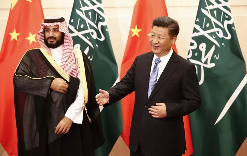 (FILES) In this file photo Saudi Arabia's then-deputy Crown Prince Mohammed bin Salman (L) looks on as Chinese President Xi Jinping (R) gestures to greet arriving members of the Saudi delegation during a meeting at the Diaoyutai State Guesthouse in Beijing on August 31, 2016. - When Chinese President Xi Jinping visits Saudi Arabia from December 7, 2022, the oil-rich kingdom will seek mostly economic gains rather than a meaningful shift away from its long-time protector the United States, analysts say. Xi will arrive for a three-day visit including meetings with Saudi royals, the regional Gulf Cooperation Council and other Middle East leaders, Saudi state media said. (Photo by Rolex DELA PENA / POOL / AFP)